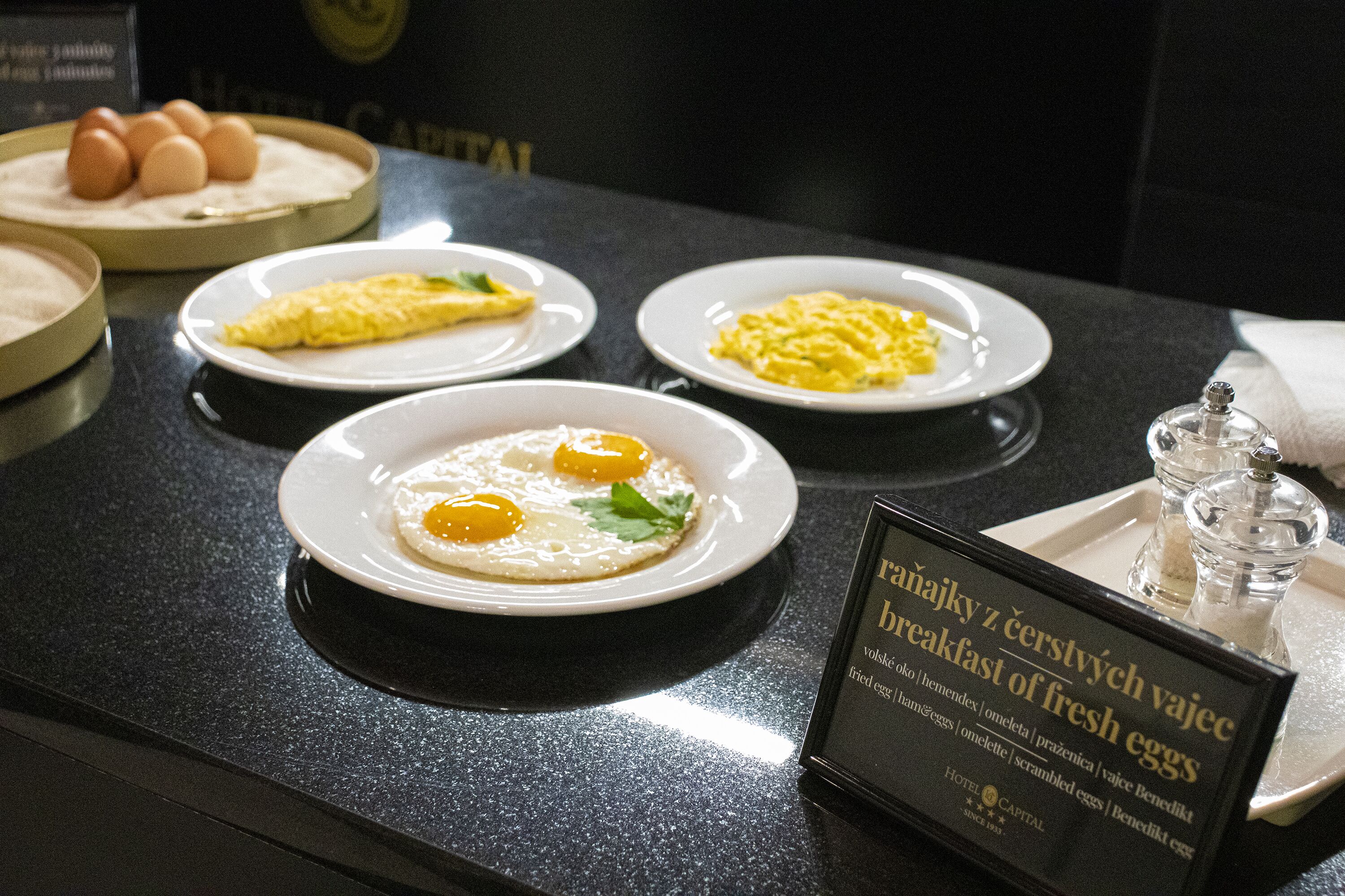 Un buffet della colazione con diversi piatti, tra cui uova strapazzate, omelette e uova fresche.