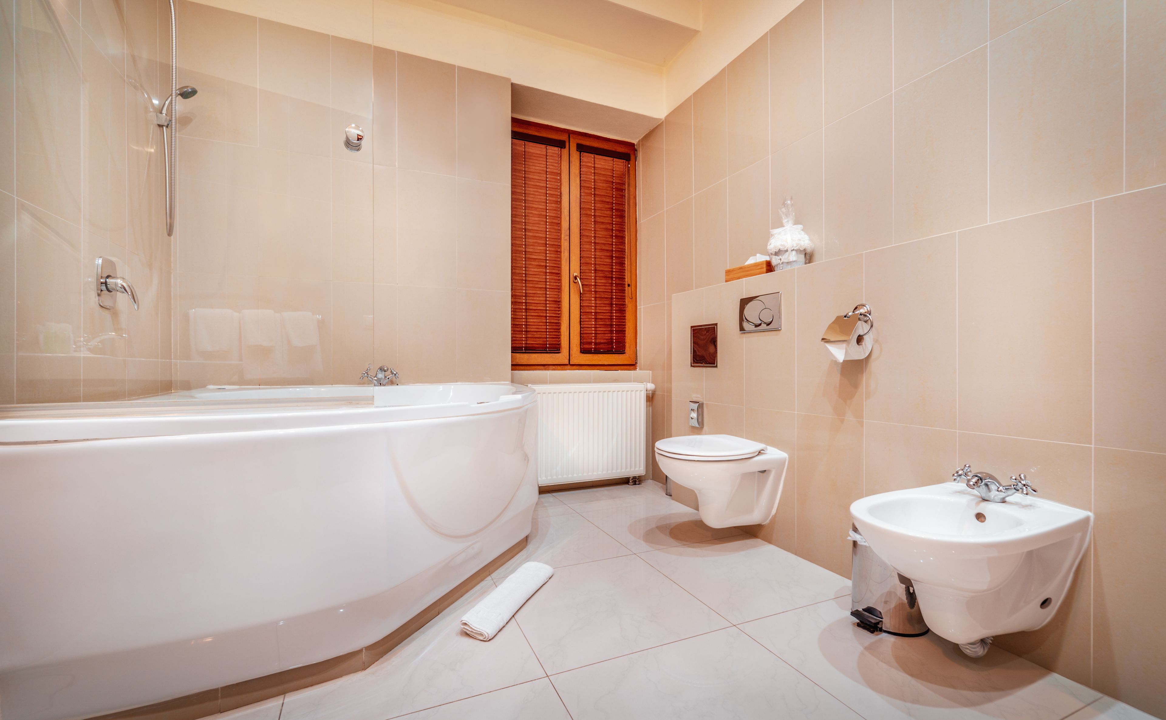 A modern bathroom with a large bathtub, a toilet, and a sink.