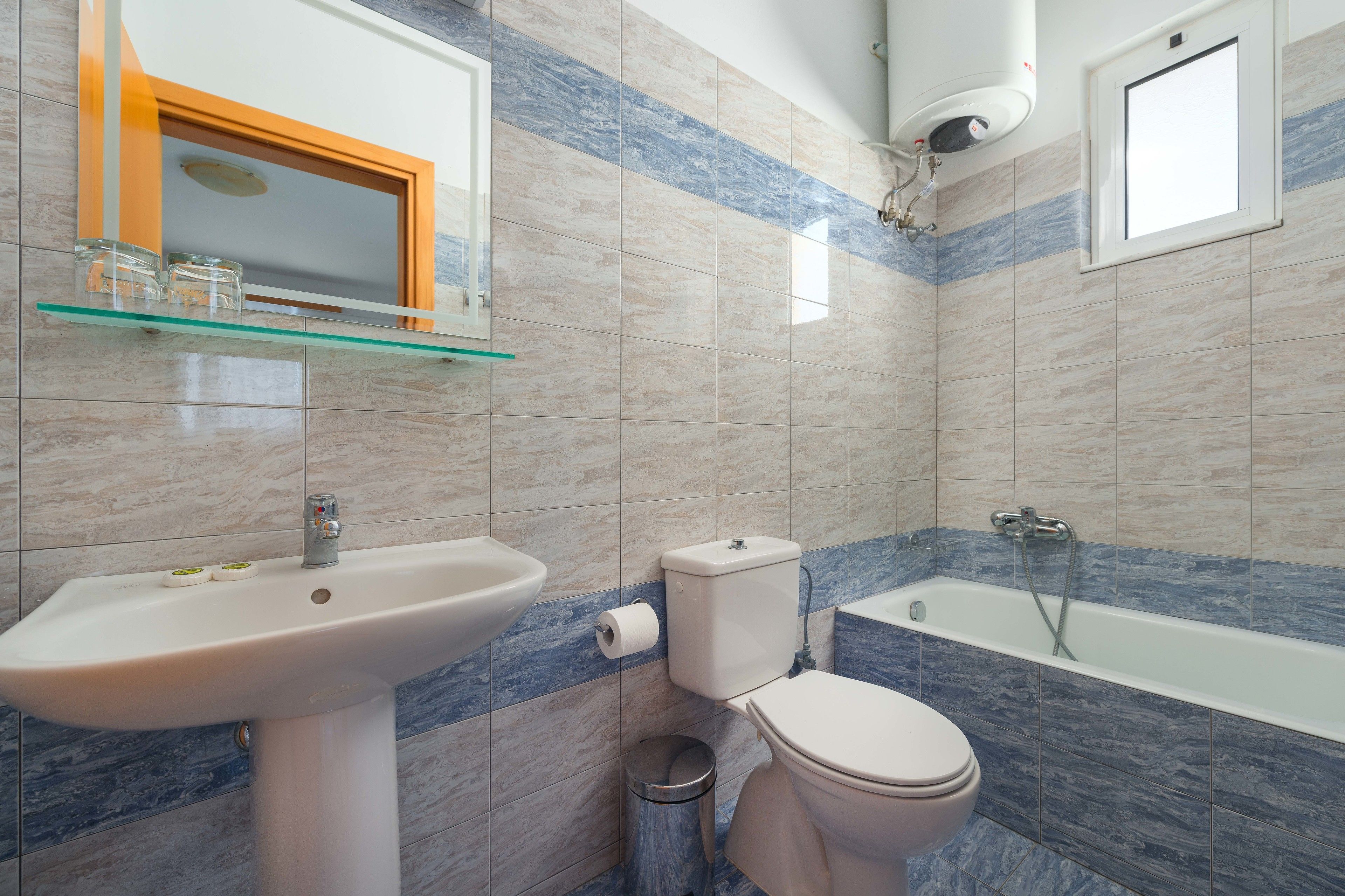 A bathroom with a sink, toilet, and bathtub.