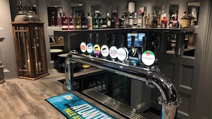 Zona de bar con una vitrina de grifos mostrando varias marcas de cerveza y un letrero que dice 'ATLANTIC PALE ALE'.