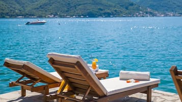 Privatstrand, Liegestühle, Sonnenschirme, Strandtücher