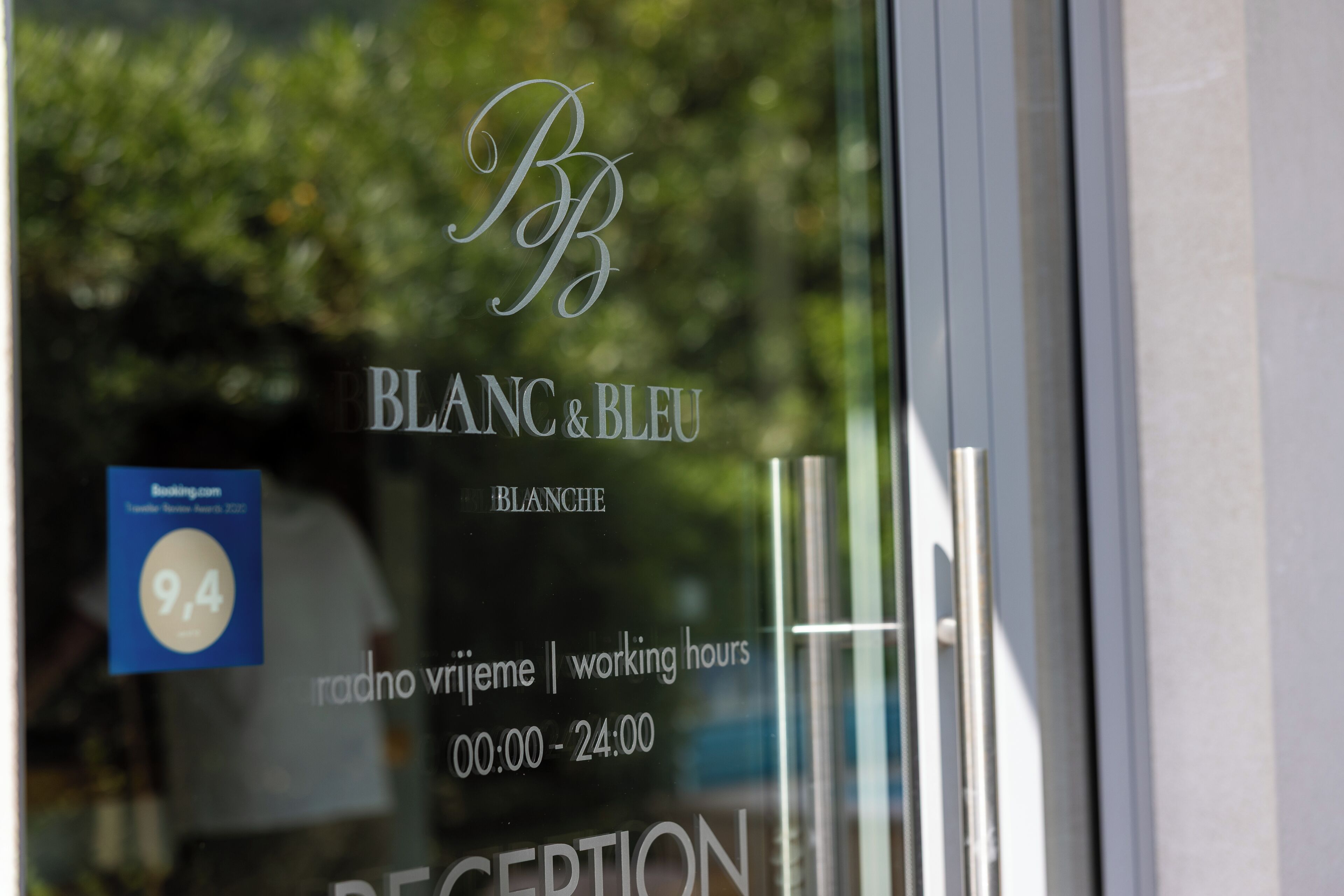 A glass door with the text 'BLANC & BLEU' and 'radno vrijeme | working hours 00:00 - 24:00' indicating the name and 24-hour availability.