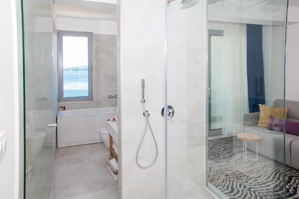 Et moderne badeværelse med en glasbrusekabine, badekar og toilet.