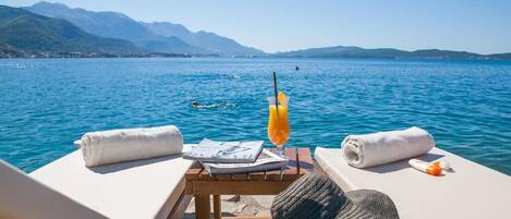 Privat strand, solstolar, parasoller och strandhanddukar