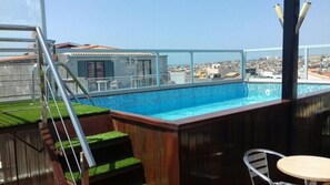 A rooftop swimming pool with a view of the cityscape. - Hotel Santiago (Praia)