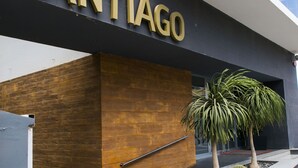 Uma entrada de hotel moderna com uma placa de destaque que diz "HOTEL SANTIAGO".
