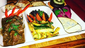 A variety of dishes including meat, vegetables, and cheese on a rectangular plate. - Eco Yourte Les Airelles (Saint-Antheme)