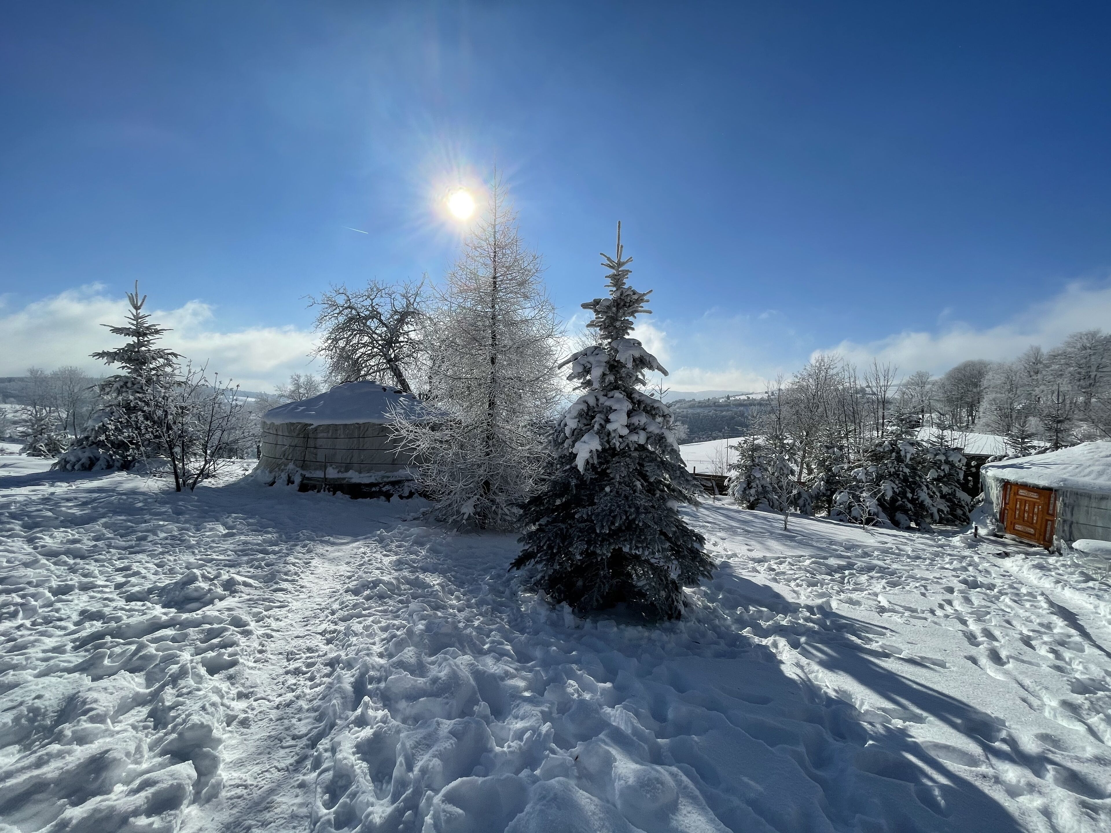 Et snøklædt landskab med klar himmel og et solskinnende sollys.