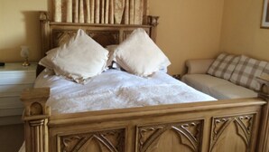 A bedroom with a large bed, two pillows, a bedside table, and a chair. - The old Farm House (Berwick-upon-Tweed)
