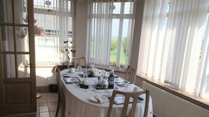 A dining area with a round table set for four, white tablecloth, and chairs. - The old Farm House (Berwick-upon-Tweed)