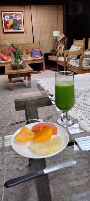 A dining table with a plate of food and a glass of green drink.