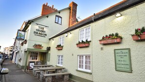 A building with a sign reading "The Green Dragon Accommodation" and a signboard stating "Comfortable Bar, Real Ales, Food Available, All Rooms En Suite." - The Green Dragon (Wellington)
