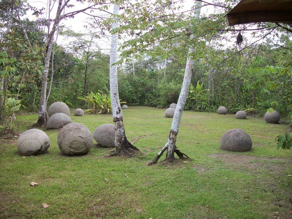 Un jardín con árboles y grandes piedras esféricas.