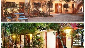 A two-story building with a courtyard, outdoor seating, and a hammock. - Tropical Sands Dominical Eco Inn (Bahía Ballena)