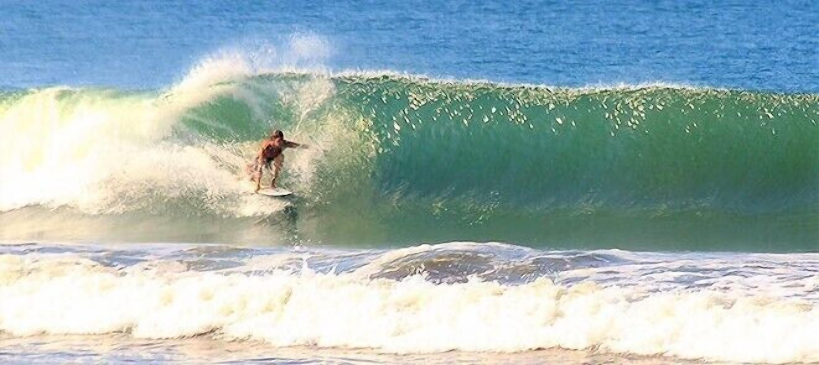 Um surfista deslizando numa onda grande.