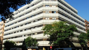 A multi-story building with a modern architectural design, featuring a series of balconies and large windows. - Apartamentos Goya 75 (Madrid)