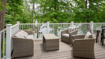 A deck with wicker furniture and a white railing.