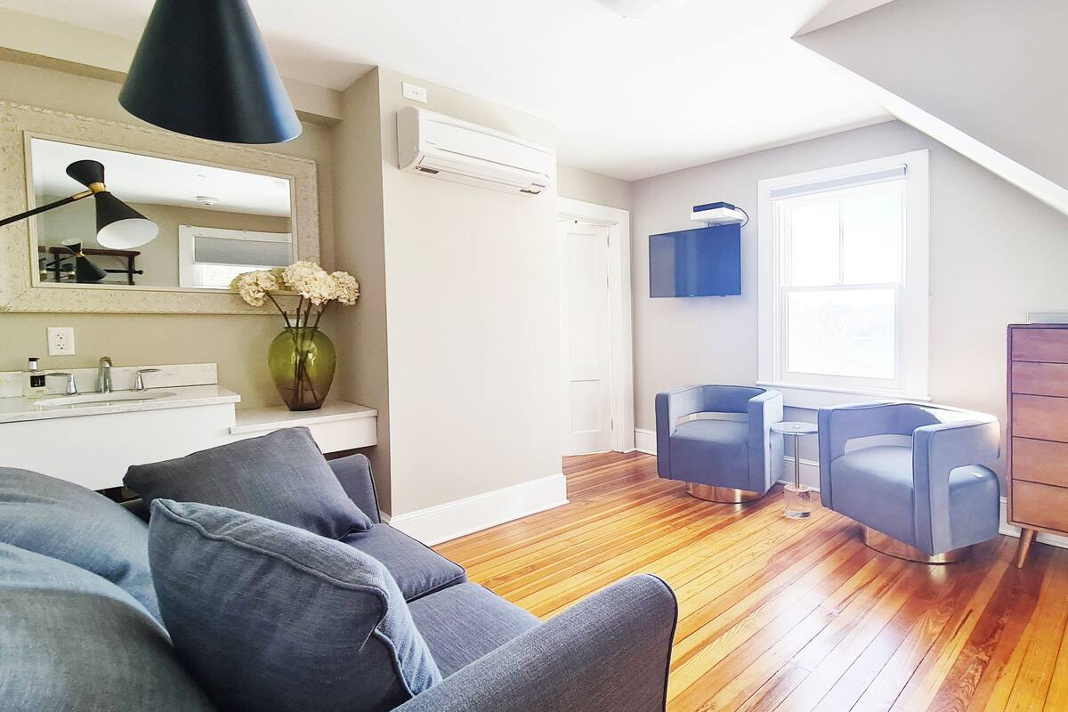 A modern living room with a sofa, a coffee table, a TV, and a wooden dresser.