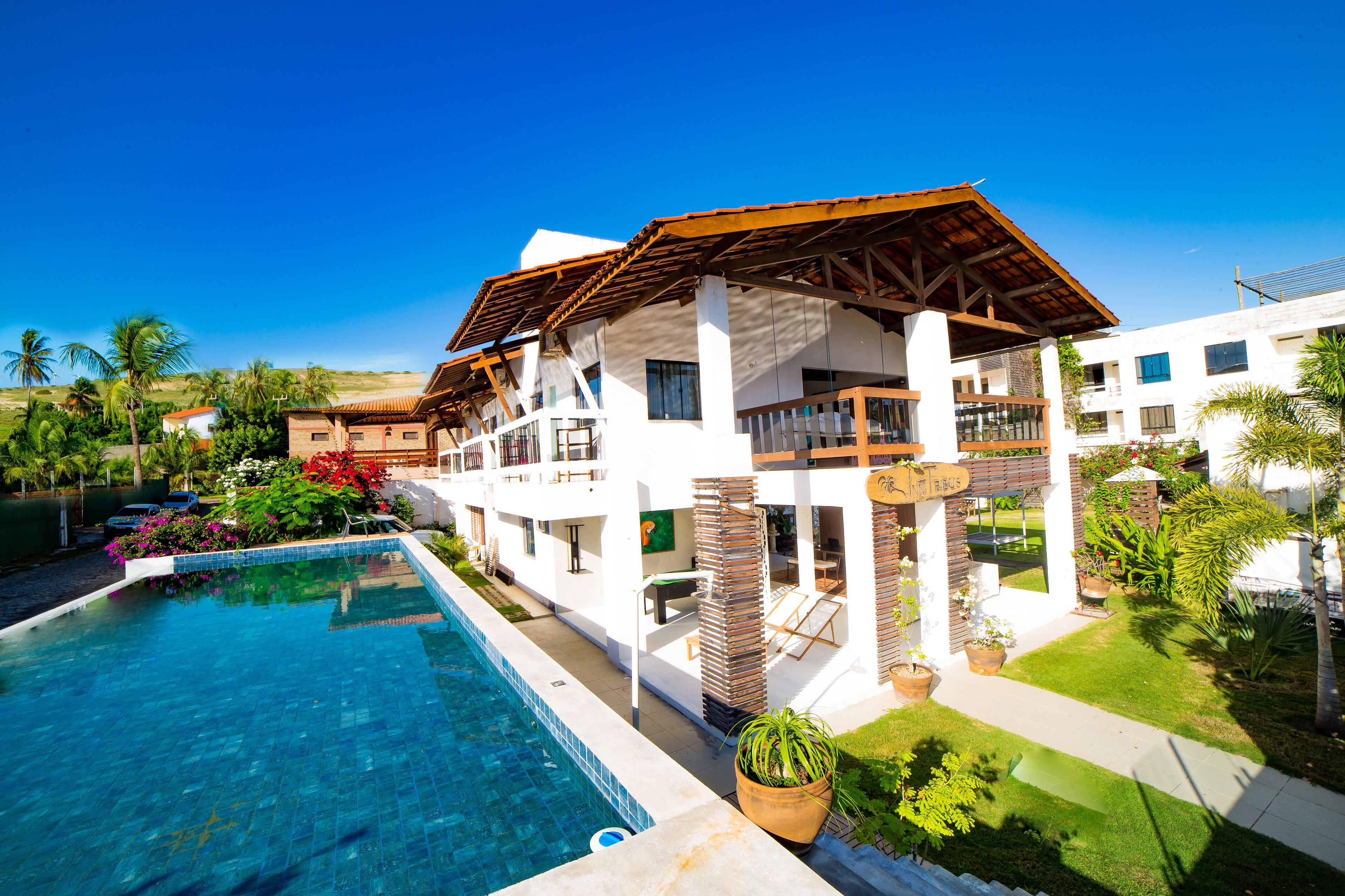 Una piscina al aire libre, sombrillas, sillones reclinables de piscina