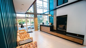 Un vestíbulo de hotel con mostrador de recepción, zona de estar y chimenea.