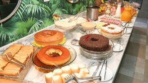 Un bufé con diversos postres y bebidas.