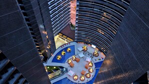 A high-rise building with a circular atrium featuring seating areas and a central fountain. - Grupo Vip Landscape Fortaleza (Fortaleza)