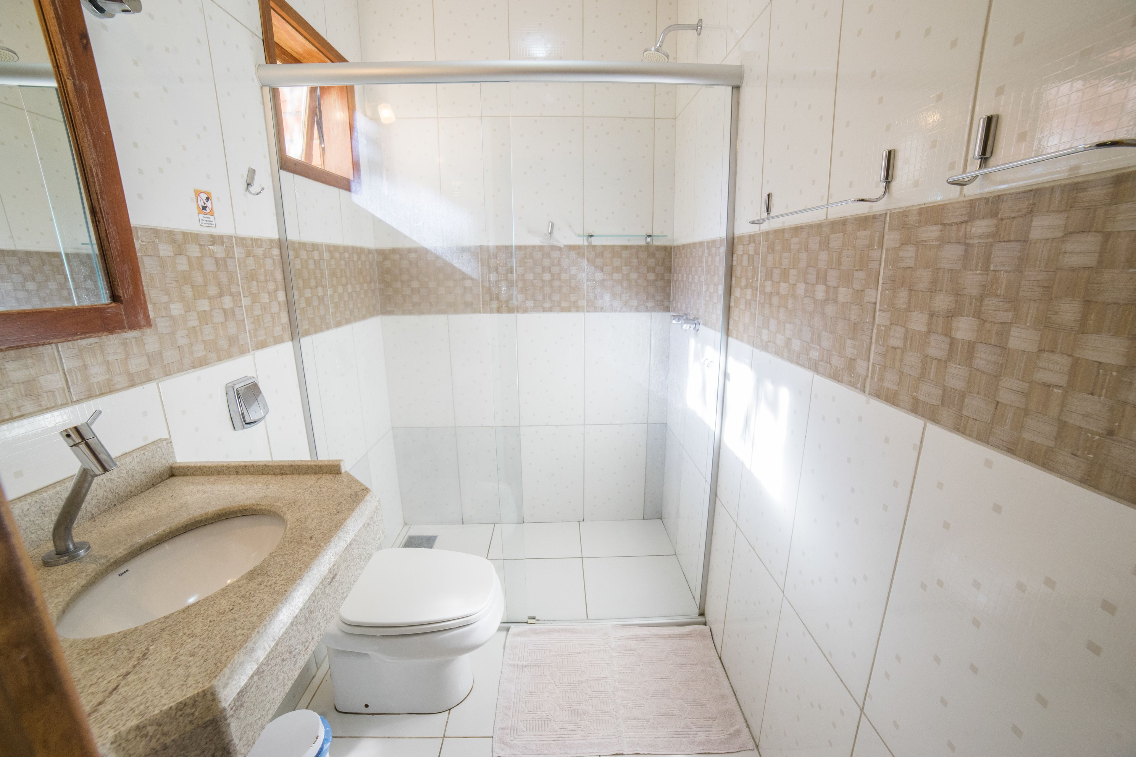 Une salle de bain équipée d’une douche, de toilettes, d’un lavabo et d’un miroir.