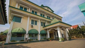 A two-story building with a green and white facade, multiple windows, and a covered entrance area. - Permata Hijau by Zuzu (North Cirebon)