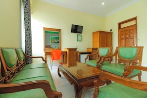 A room with a wooden sofa set, a dining table, a television, and a wooden cabinet. - Permata Hijau by Zuzu (North Cirebon)