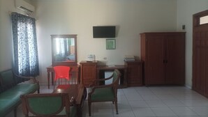 A room with a dining table, chairs, a sofa, a TV, and a wardrobe. - Permata Hijau by Zuzu (North Cirebon)