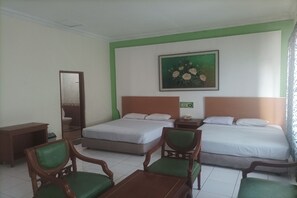 Une chambre d’hôtel avec deux lits, un bureau, une chaise, un miroir et un tableau au mur.