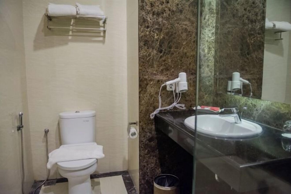 A bathroom with a toilet, sink, and towel rack.