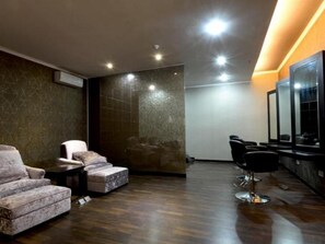 A modern interior with a seating area, a mirror, and a wall with a textured pattern.