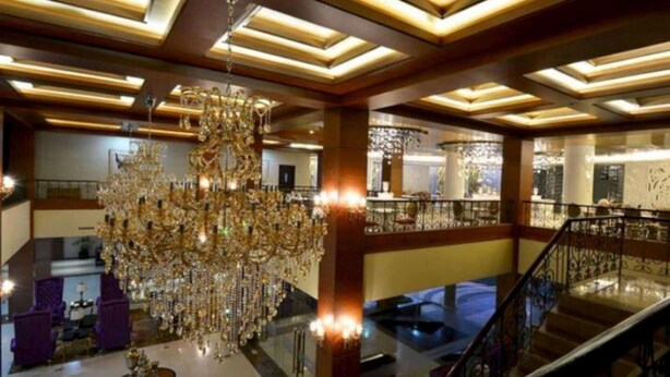 A grand lobby with a large chandelier, a staircase, and a high ceiling with geometric lighting. - Sutan Raja Hotel and Convention Cen (Soreang)