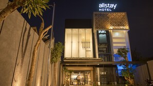 A modern hotel with a prominent 'Allstay Hotel' sign, large glass entrance, and a well-lit facade. - Allstay Ecotel Yogyakarta (Depok)