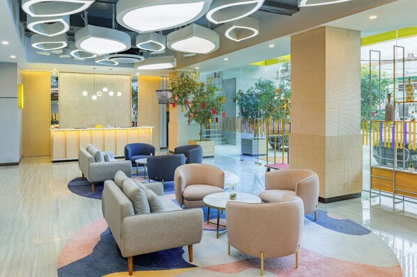 A modern lobby with seating areas, a reception desk, and a view of the outdoors. - YELLO Hotel Samarinda (Samarinda)