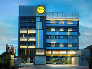A modern hotel building with a prominent yellow sign, multiple balconies, and a well-lit entrance. - YELLO Hotel Samarinda (Samarinda)