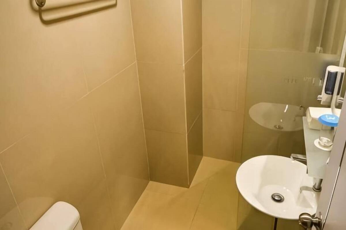 A bathroom with a toilet, a sink, and a glass shower enclosure.