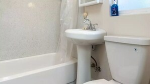 A bathroom with a white bathtub, a white sink, and a toilet.