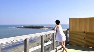 Enjoy breathtaking ocean views from this balcony overlooking the beach and a distant island.