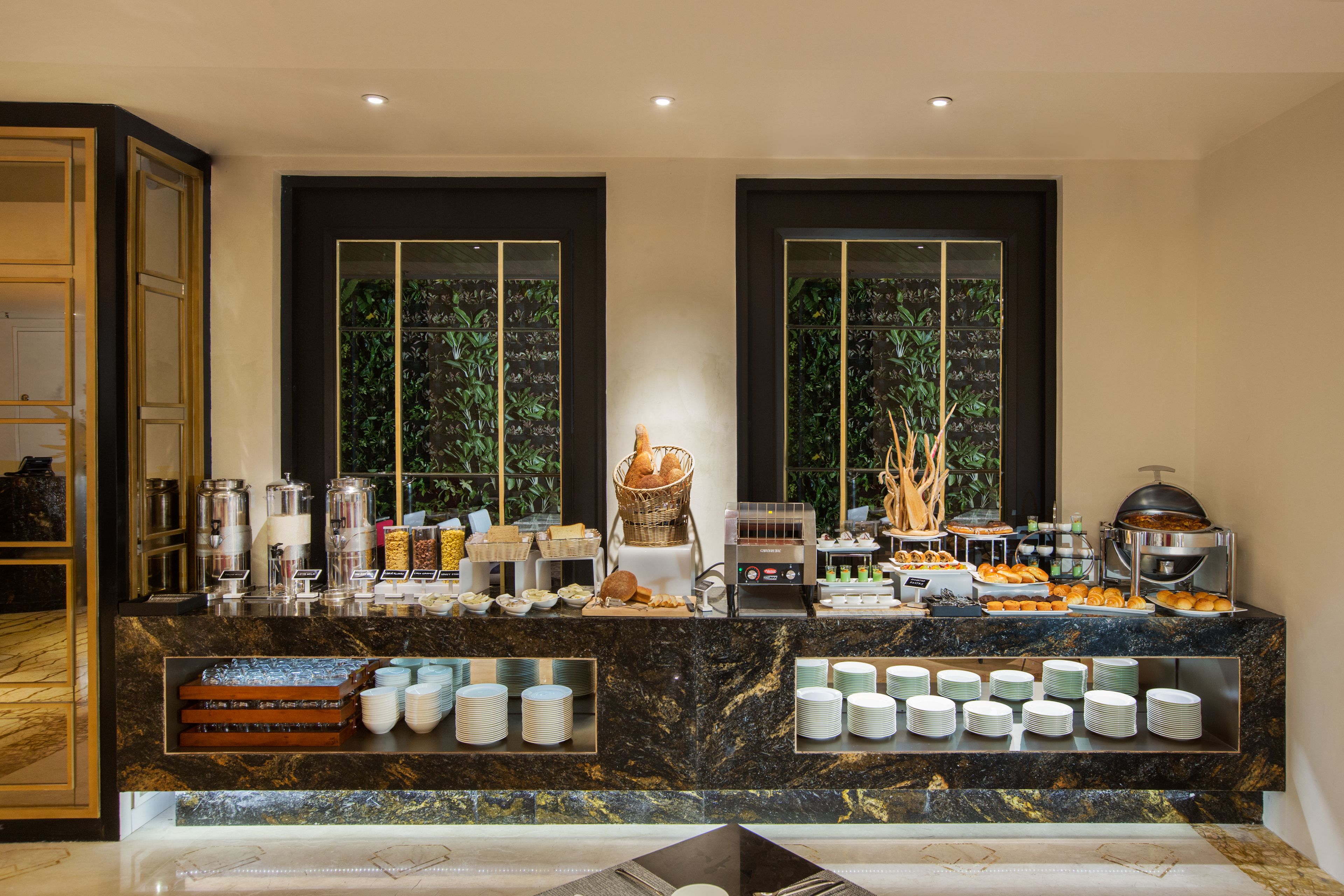A buffet setup with various food items and serving utensils.