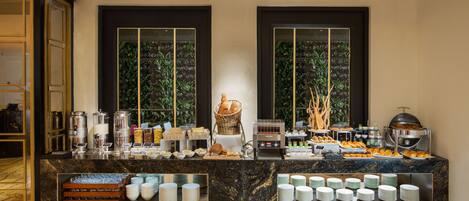 A buffet setup with various food items and serving utensils.