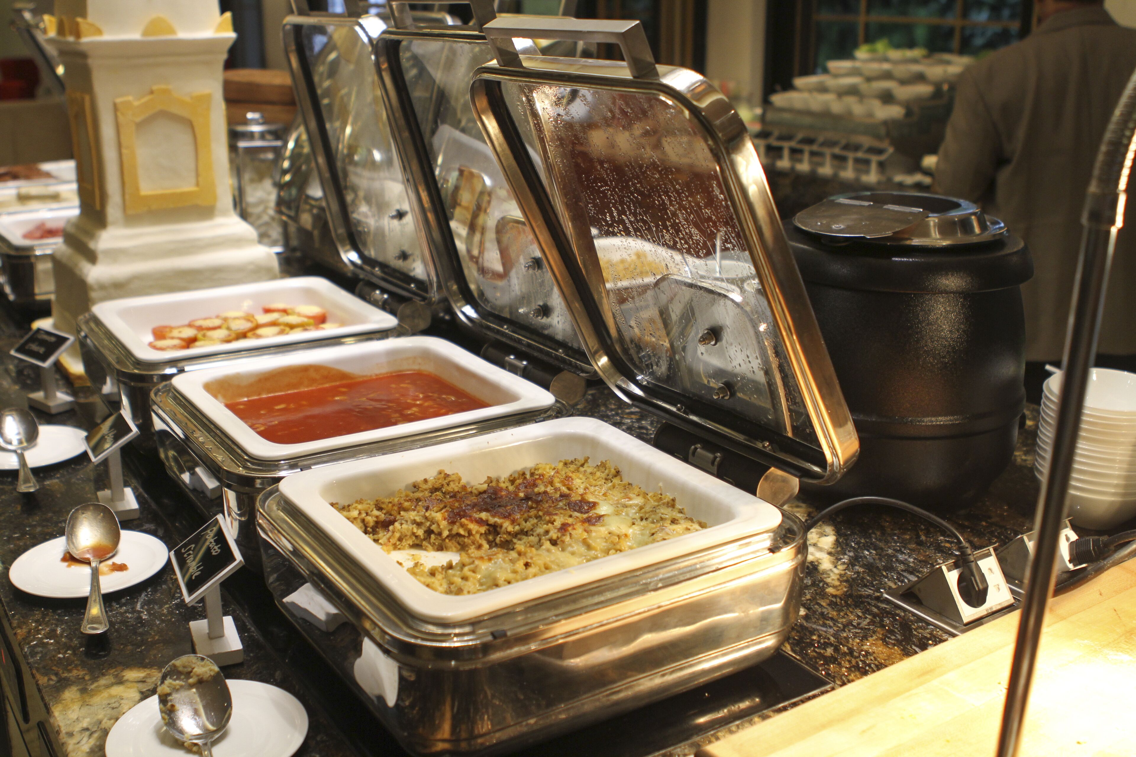 A buffet with various food containers and serving utensils.