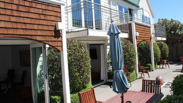 Een tweelaags huis met een balkon, een buiten zitgedeelte en een overdekte patio.