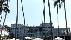 Ein Resort mit Pool, Palmen und einem modernen, mehrstöckigen Gebäude.