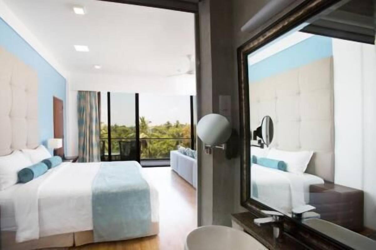 Une chambre d’hôtel moderne dotée d’un grand lit, d’une salle de bain et d’un balcon avec vue.