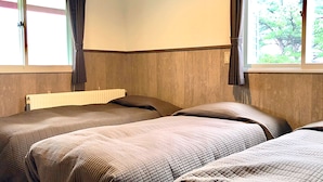 Una habitación con dos camas, un radiador y una ventana con cortinas.