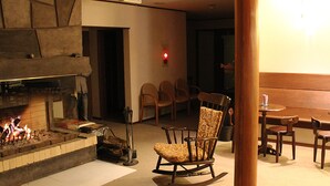 Una habitación acogedora con chimenea, sillas de madera y una mesa de comedor.