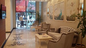 A lobby with a seating area, a reception desk, and a view of the outside. - MB Deluxe Hotel (Istanbul)
