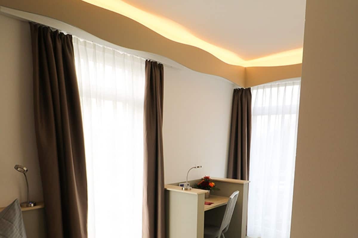 Ein Hotelzimmer mit Bett, Schreibtisch und Stuhl.